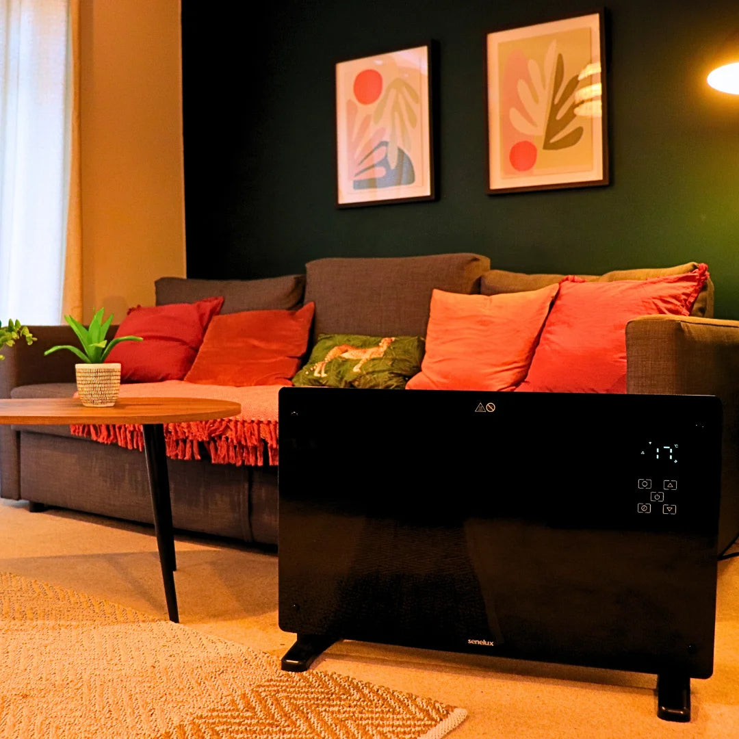 Black glass panel heater with a sofa and lamp behind it whilst showing the room's temperature with LED lights