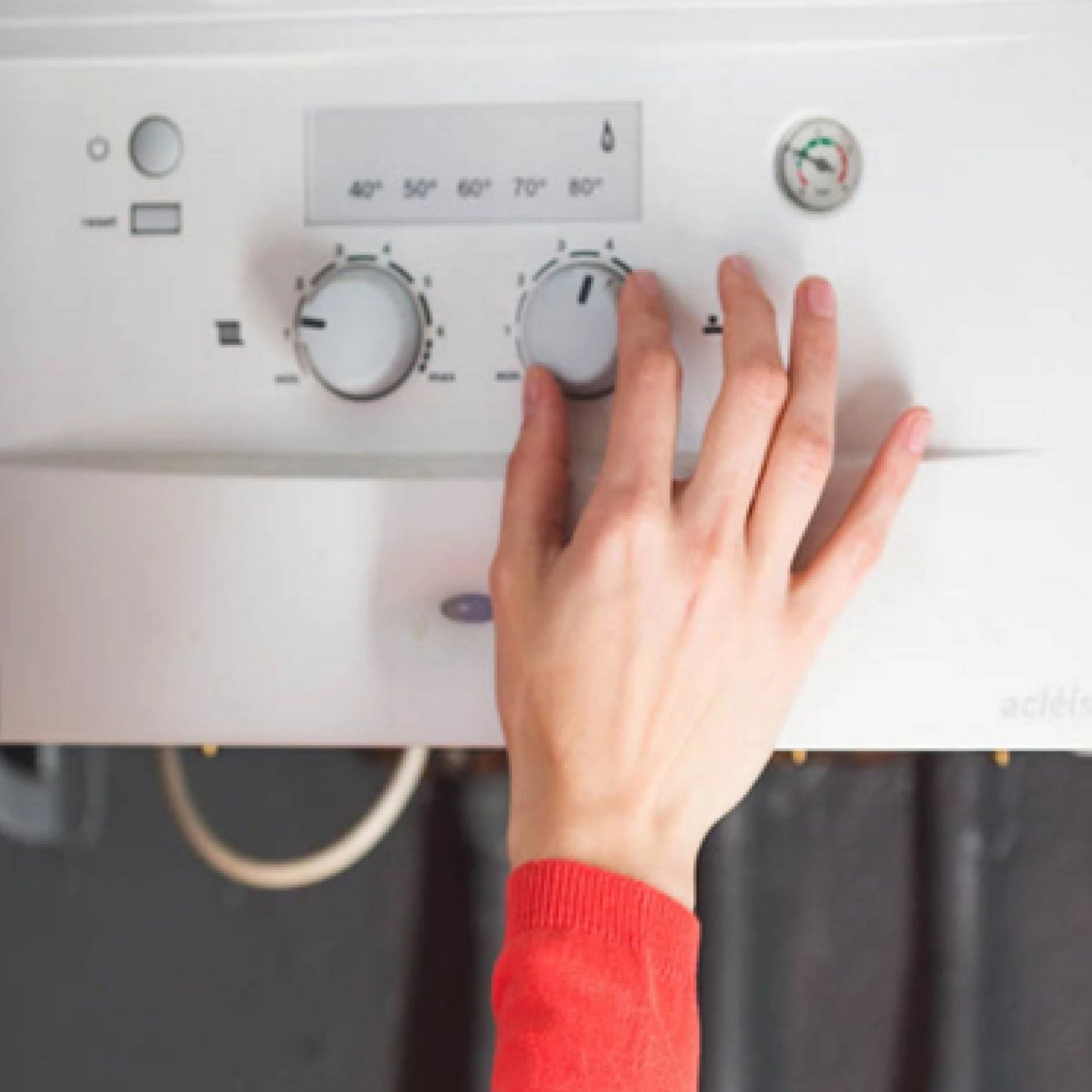 A woman's hand adjusting a thermostat indicating that she is energy efficient with Senelux products and saving money.