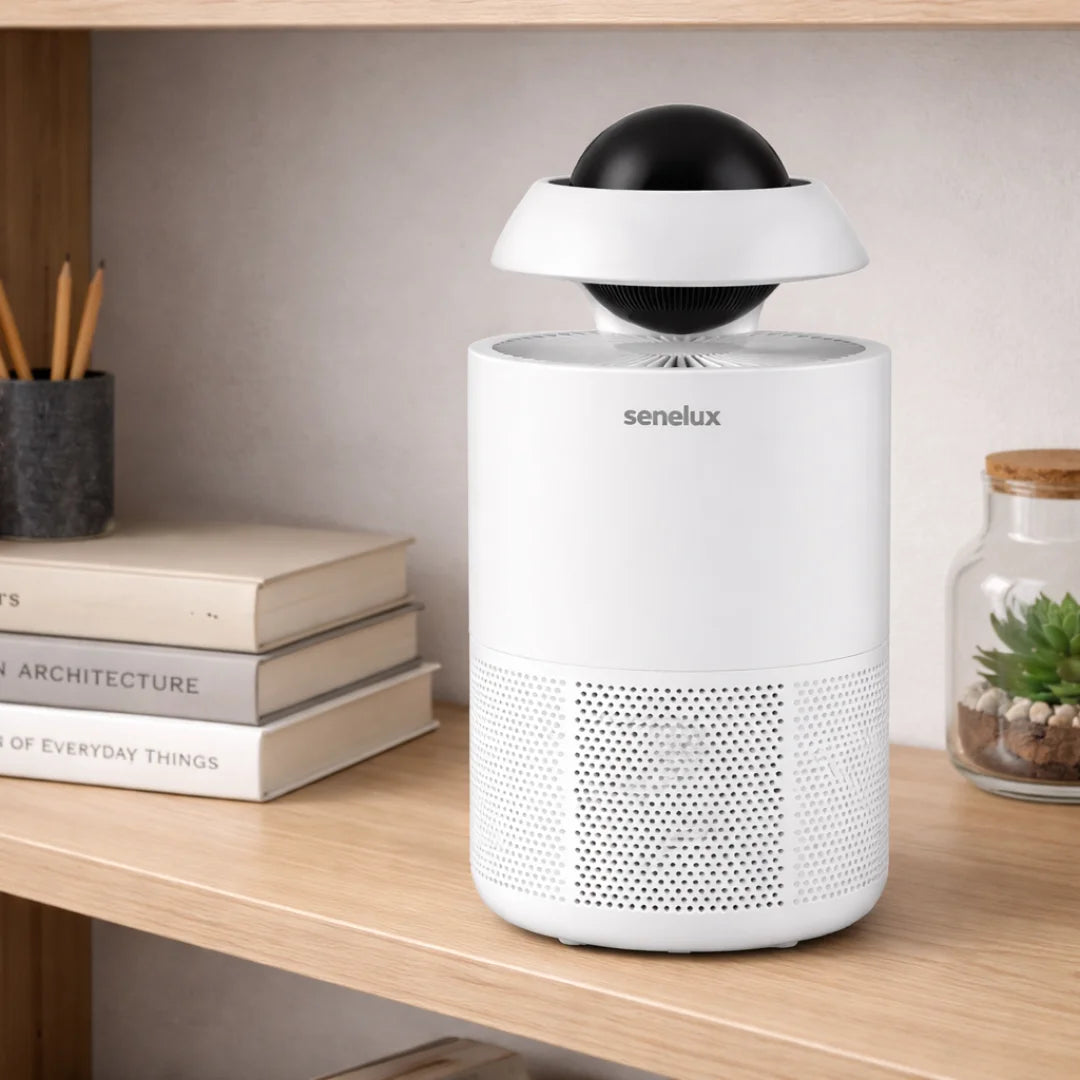 White Senelux air purifier on a wooden desk with books and a plant in the background