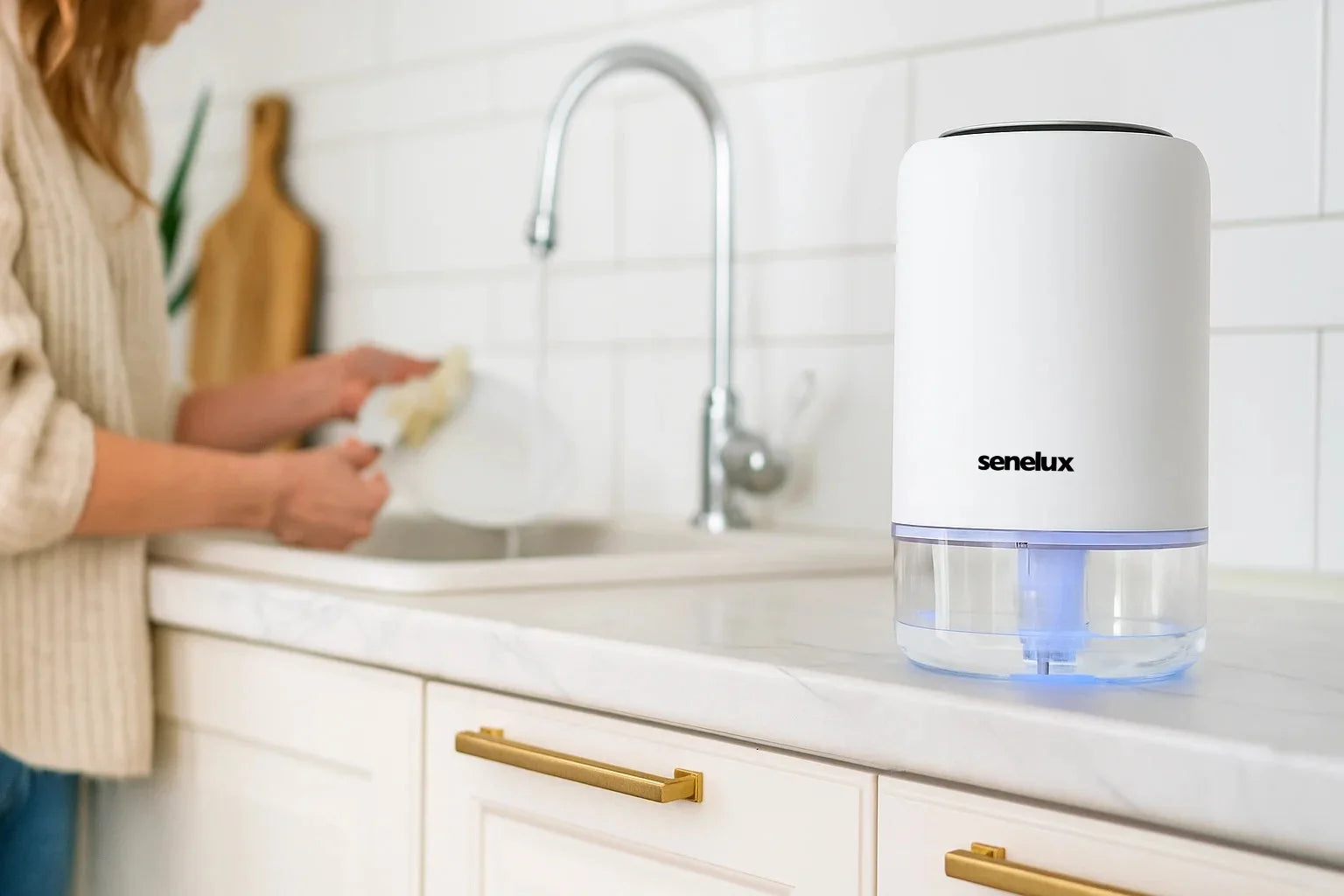 Person washing dishes in a kitchen with a Senelux water filter on the counter.