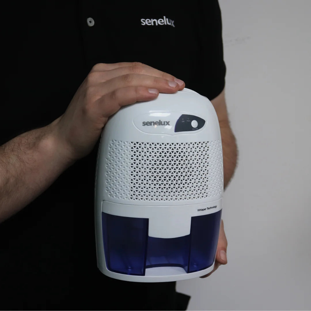 A picture of a Senelux member of staff holding up a Senelux Mini Dehumidifier